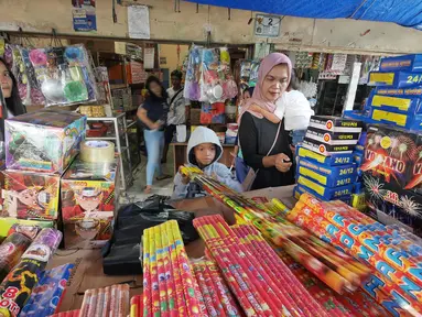 Pembeli saat memilih petasan di pasar gembrong, Jakarta, Senin (11/6). Imbas meledakanya pabrik petasan di tanggerang beberapa waktu lalu, harga petasan dan kembang api naik saat menjelang Lebaran 2018. (Liputan6.com/Herman Zakharia)