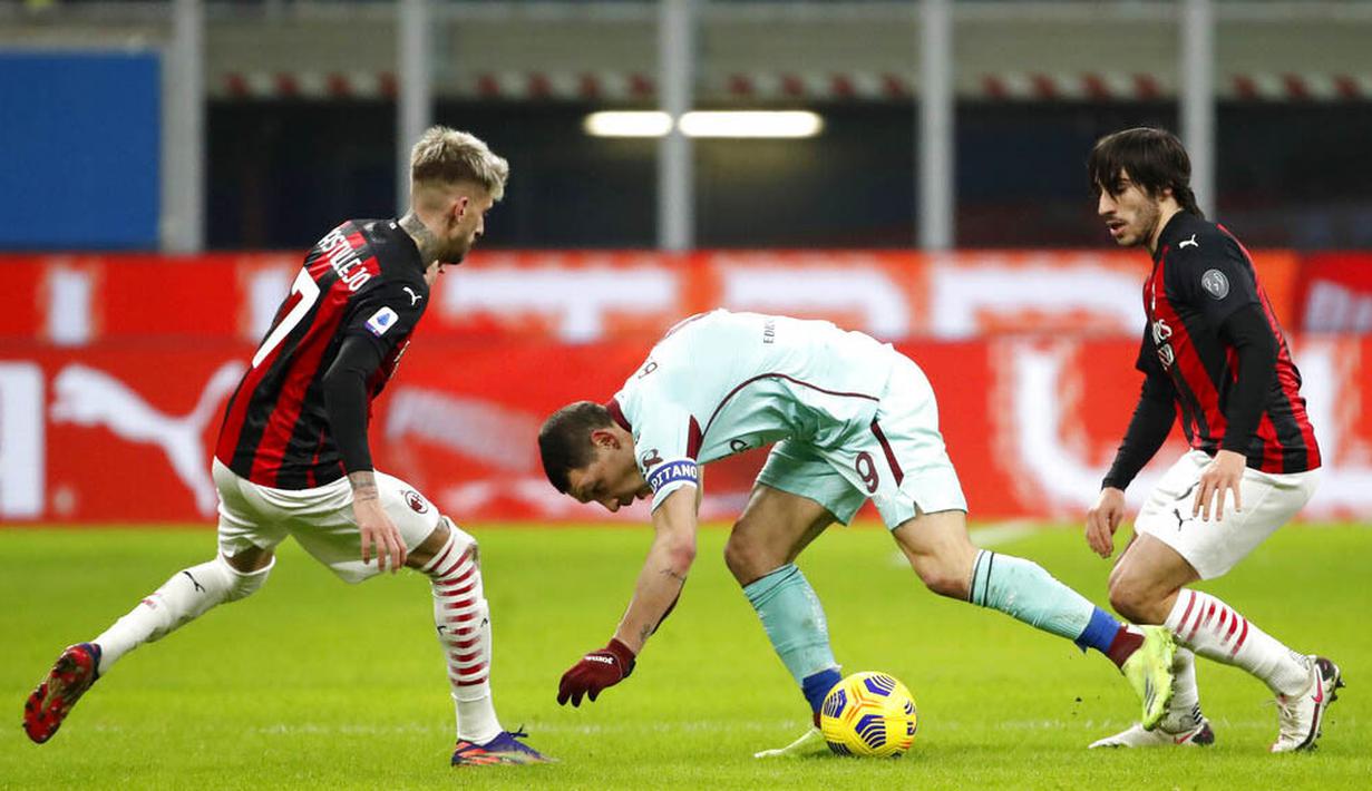 Striker Torino, Andrea Belotti, berusaha melewati pemain AC Milan pada laga Liga Italia di Stadion San Siro, Sabtu (9/1/2021). AC Milan menang dengan skor 2-0. (Fabio Ferrari/LaPresse via AP)