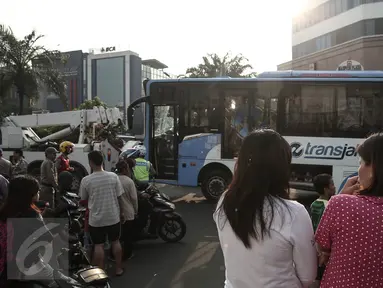 Sejumlah warga berdatangan ke lokasi bus TransJakarta yang terlibat kecelakaan dengan kereta api Senja Utama Solo di perlintasan kereta Mangga Dua, Jakarta, Kamis (19/5). Peristiwa tabrakan itu juga melibatkan mobil Avanza. (Liputan6.com/Faizal Fanani)