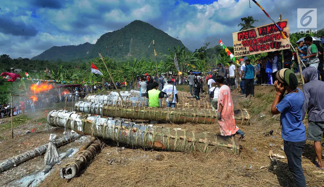 Warga menyalakan meriam karbit selama kegiatan Pesta Rakyat Sukamakmur di Desa Sukamakmur, Bogor, Minggu (16/6/2019). Kegiatan berupa perang meriam karbit yang terbuat dari batang pohon kapuk antar desa setelah perayaan lebaran ini terakhir diselenggarakan 13 tahun silam. (merdeka.com/Arie Basuki)