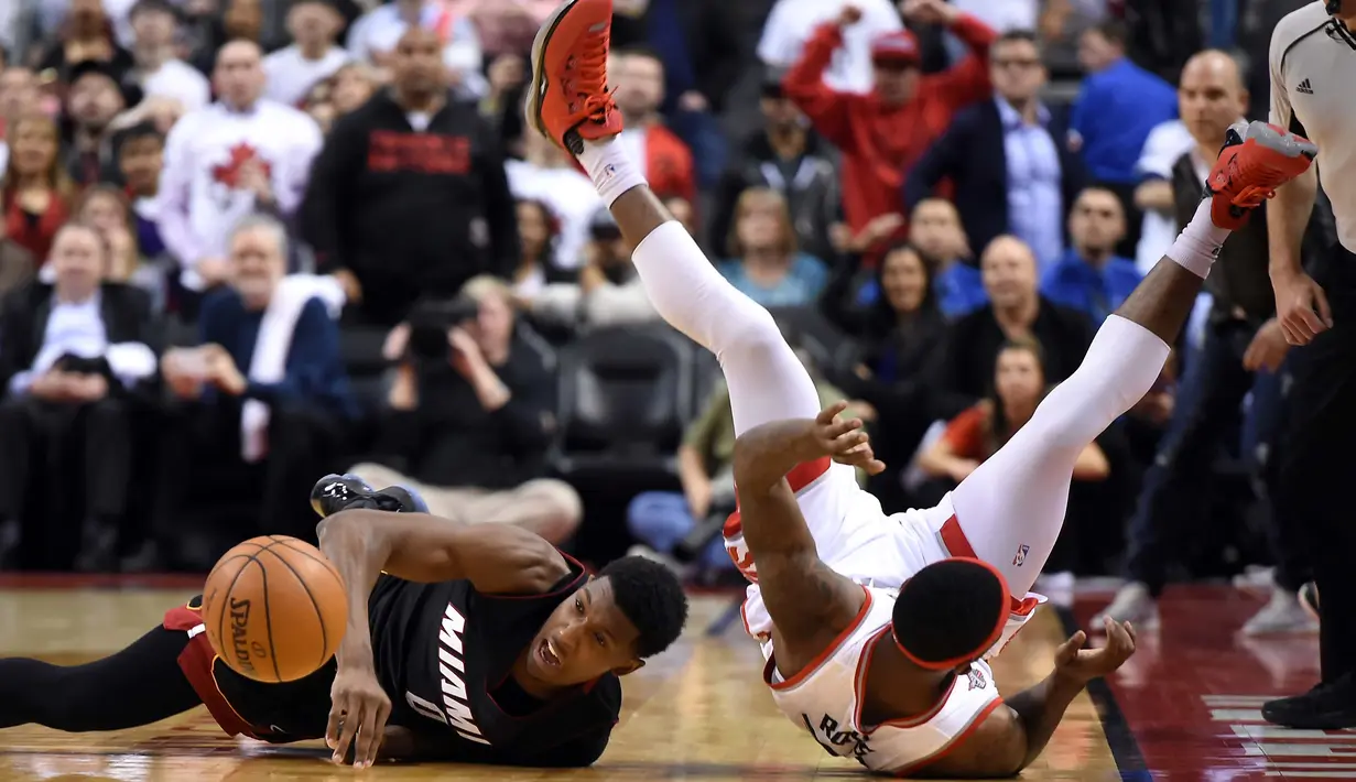 Miami Heat guard Josh Richardson (0) terjatuh saat berebut bola dengan Toronto Raptors guard Terrence Ross (32) ipada NBA Playoffs di Air Canada Centre, Toronto, Selasa (3/5/2016). (Reuters/Mandatory/Dan Hamilton-USA TODAY Sports)