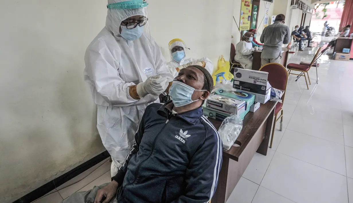 Petugas medis saat melakukan tes Covid-19 kepada salah satu warga di GOR Kecamatan Makasar, Jakarta Timur, Senin (17/5/2021). Hari ini tercatat sebanyak 71 warga yang diundang oleh RT di wilayah masing-masing menjalani tes Covid-19, baik tes antigen maupun PCR. (merdeka.com/Iqbal S Nugroho)
