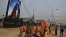 Buruh wanita India berkumpul sebelum mengangkat bata untuk pembangunan konstruksi Trump Tower atau Menara Trump di Kolkata, India (20/2). (AFP/ Dibyangshu Sarkar)