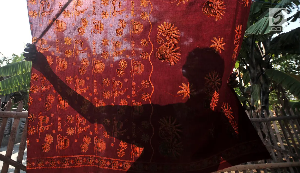 Pengrajin menjemur kain batik Betawi usai dicuci di rumah produksi Batik Seraci, Kampung Kebon Kelapa, Bekasi, Jawa Barat, Selasa (2/10). Rumah produksi Batik Seraci memiliki 15 pengrajin. (Merdeka.com/Iqbal Nugroho)