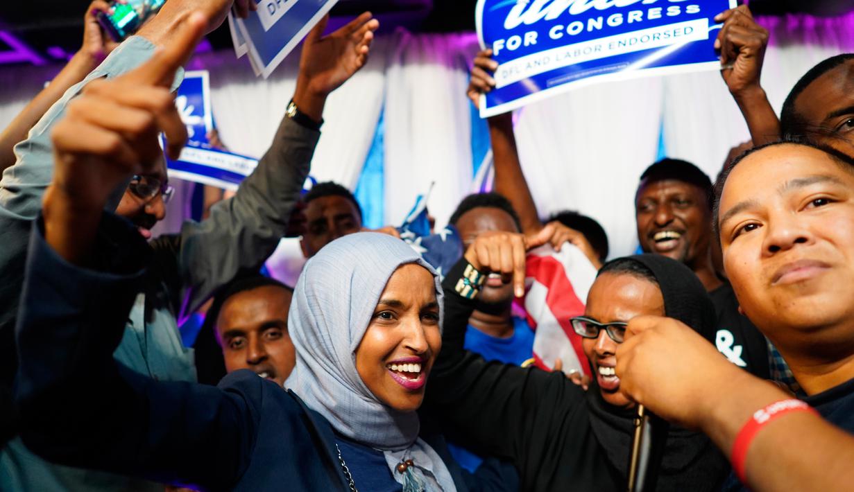 Ilhan Omar bersama pendukungnya merayakan kemenangan putaran pertama pemilihan Distrik Kongres ke-5 di Minneapolis, AS, Selasa (14/8). Omar menjadi muslimah Somalia pertama yang terpilih sebagai anggota Kongres AS. (Mark Vancleave/Star Tribune via AP)