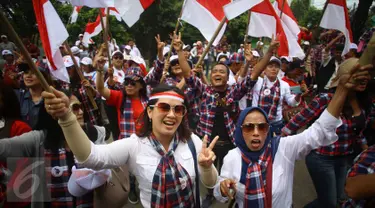 Pendukung Cagub DKI Basuki T Purnama meneriakkan yel di luar ruang sidang kasus penistaan agama, Jakarta, Selasa (10/1). Dengan mengenakan atribut kotak-kotak, massa membawa bendera Indonesia serta melakukan orasi damai. (Liputan6.com/Immanuel Antonius)
