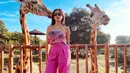 Di sini, Jessica Iskandar tampil mengenakan crop top bernuansa merah muda keunguan bermotif abstrak dengan detail pita di bagian depan, dipadu dengan celana panjang bernuansa senada. Foto: Instagram.