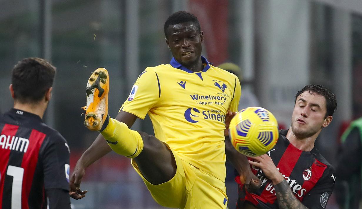 Gelandang Hellas Verona, Destiny Udogie (tengah), berebut bola dengan bek AC Milan, Davide Calabria dalam lanjutan Liga Italia Serie A pekan ke-7 di Stadion San Siro, Milan, Senin (9/11/2020). Hellas Verona bermain imbang 2-2 dengan AC Milan. (AP Photo/Antonio Calanni).