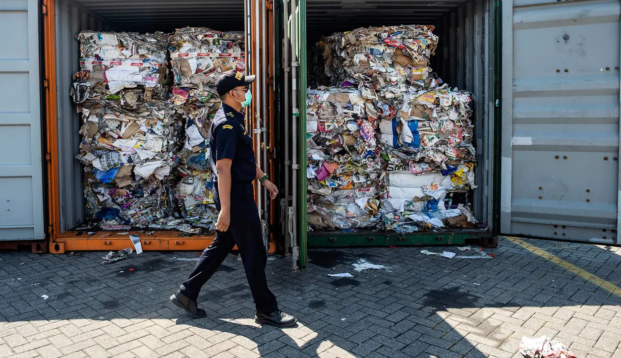 Petugas Bea Cukai Tanjung Perak berjalan melewati kontainer berisi sampah asal Australia di Pelabuhan Tanjung Perak, Surabaya, Jawa Timur, Selasa (9/7/2019). Delapan kontainer sampah seberat 210 ton tersebut diimpor PT MDI dari Australia. (JUNI KRISWANTO/AFP)