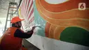 Petugas PPSU melukis mural dengan warna-warna cerah sehingga kolong Semanggi terlihat lebih cerah. Liputan6.com/Faizal Fanani)