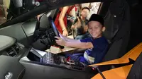 Anak yatim Panti Asuhan Mizan Amanah terlihat sumringah menjajal pegang setir Lamborghini Aventador. (Liputan6.com/Khizbulloh Huda)