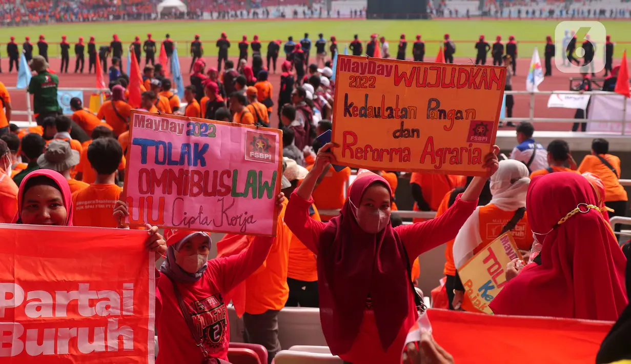 Sejumlah buruh membawa poster saat mengikuti aksi bertajuk May Day Fiesta 2022 di Stadion Gelora Bung Karno (GBK), Senayan, Jakarta Pusat, Sabtu (14/5/2022). Dalam aksi kali ini, massa buruh membawa 18 tuntutan, di antaranya menolak omnibus law UU Cipta Kerja, wujudkan kedaulatan pangan dan dan menolak kenaikan Pajak Pertambahan Nilai (PPN). (Liputan6.com/Angga Yuniar)