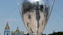 Warga foto di depan replika raksasa trofi Liga Champions ditempatkan di depan Katedral St Sophia, di Kiev, Ukraina, (23/5). Liverpool akan melawan Real Madrid di Final Liga Champions pada 26 Mei di stadion Olympiyski di Kiev. (AP Photo / Efrem Lukatsky)