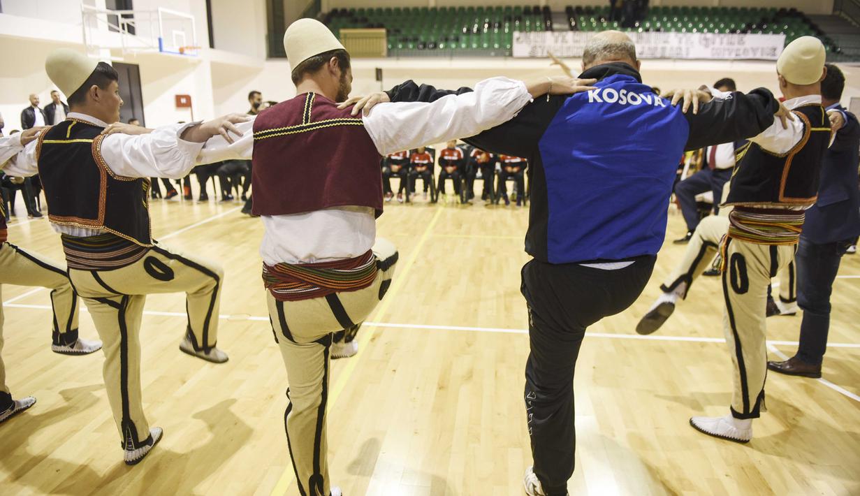 Warga Kosovo mengenakan pakaian tradisional menari merayakan diterimnya Kosovo sebagai anggota UEFA,di Mitrovica. (3/5/2016).   (AFP/Armend Nimani)