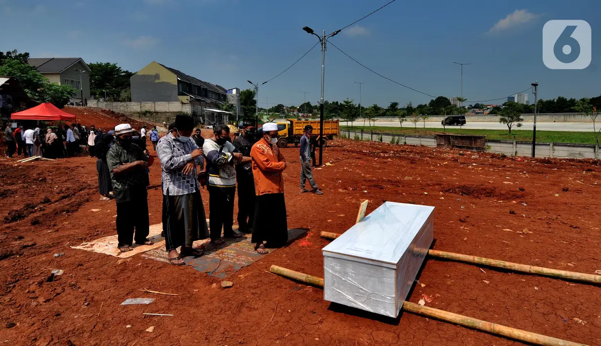 Keluarga korban mensalatkan jenazah untuk dimakamkan di lahan baru tempat pemakaman umum (TPU) khusus COVID-19, Jombang, Tangerang Selatan, Banten,Senin (26/7/2021). Pemkot Tangerang Selatan membuka lahan baru TPU khusus COVID-19 yang dapat menampung 800 makam. (merdeka.com/Arie Basuki)