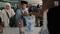 Jemaah haji Kloter 2 asal Banten antre mengambil air zam-zam di Asrama Haji Pondok Gede, Jakarta, Rabu (29/8). Panitia Penyelenggara Ibadah Haji (PPIH) membagikan air zam-zam sebanyak lima liter per jemaah secara cuma-cuma. (Merdeka.com/ Iqbal S. Nugroho)
