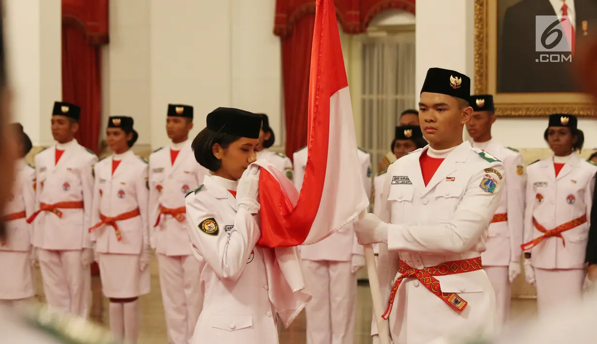 Paskibraka Nasional 2017 mencium bendera merah putih saat pengukuhan di Istana Negara, Jakarta, Selasa (15/8). Sebelum dilantik, 68 Paskibraka dari 34 provinsi di Indonesia ini menjalani pendidikan dan pelatihan di PP PON. (Liputan6.com/Angga Yuniar)