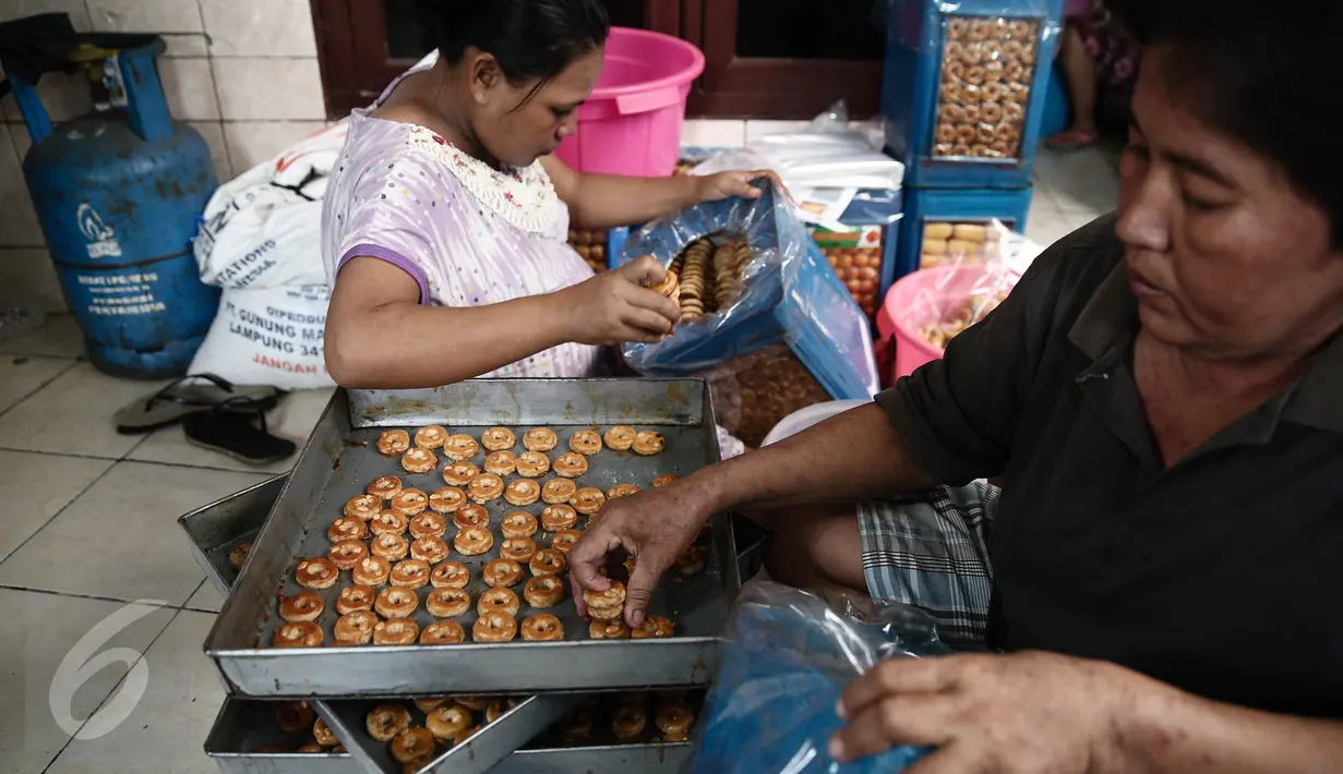 Pekerja menata kue kering kedalam kaleng di Industri kue rumahan Kwitang Pusaka, Jakarta,  (21/6). Jelang lebaran permintaan kue kering industri rumahan meningkat. (Liputan6.com/Faizal Fanani)