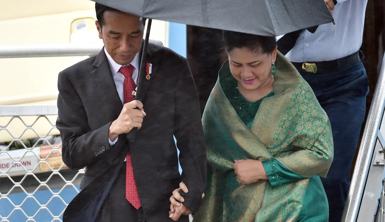 Presiden Joko Widodo atau Jokowi didampingi Ibu Iriana saat turun dari Pesawat Kepresidenan yang mendarat di Bandara Sydney, Australia, Sabtu (25/2). (AFP/Saeed Khan)