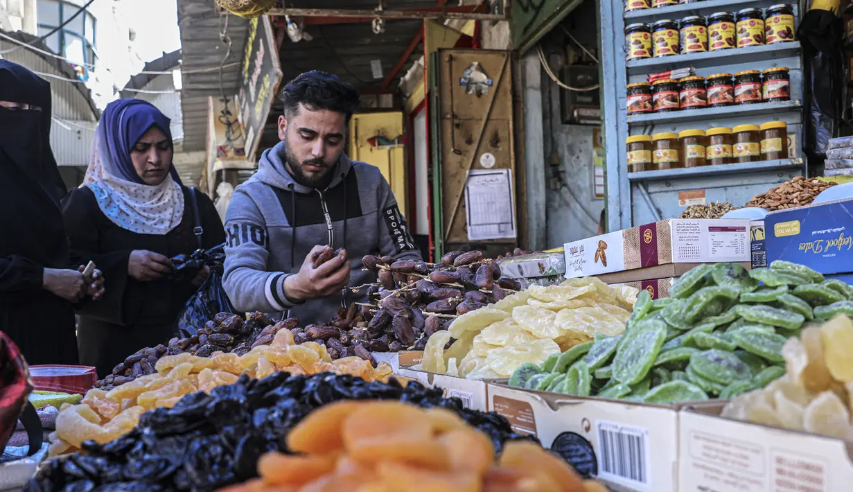 Warga membeli buah kering saat umat muslim mempersiapkan diri menyambut bulan suci Ramadhan di Khan Yunis, Jalur Gaza, Palestina, 30 Maret 2022. (SAID KHATIB/AFP)