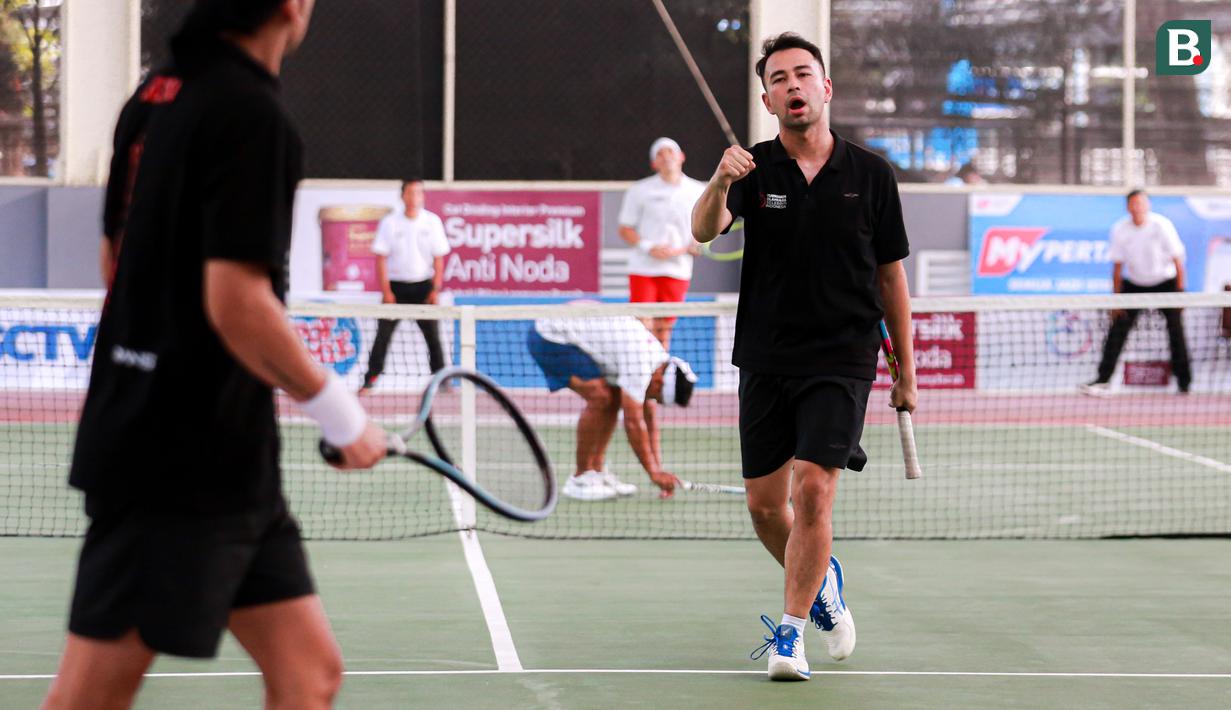 Selebritas Indonesia, Raffi Ahmad melakukan selebrasi setelah mencetak poin saat melawan pasangan Rezky Aditya dan Tanta Ginting pada laga tenis nomor ganda putra Turnamen Olahraga Selebriti Indonesia di GOR UNJ, Jakarta, Minggu (30/07/2023). Raffi yang berpasangan dengan Deddy Mahendra Desta menang dengan skor 4-6, 6-4, dan 6-4. (Bola.com/Bagaskara Lazuardi)