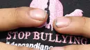 Warga membetulkan letak topi dukungan Stop Bullying saat acara Car Free Day di Kawasan Bundaran Hotel Indonesia, Jakarta, Minggu (13/5). (Liputan6.com/Helmi Fithriansyah)