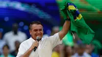 Presiden Brasil Jair Bolsonaro memegang bendera negara Brasil dalam acara peluncuran kampanyenya untuk maju kembali dalam pemilihan presiden Brasil. Acara tersebut digelar di Rio de Janeiro, Brasil, pada 24 Juli 2022. (Foto: AP/Bruna Prado)