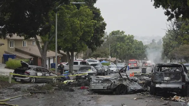 Pihak berwenang sedang memeriksa lokasi jatuhnya pesawat kecil di kawasan permukiman San Diego, AS yang menyebabkan beberapa rumah terbakar dan memaksa evakuasi di beberapa blok pada Kamis dini hari, 22 Mei 2025. (AP/Gregory Bull)