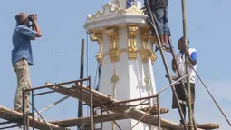 Pekerja mengecat kembali Tugu ,Yogakarta, Rabu (29/6). Pengerjaan renovasi dilakukan untuk memperindah monumen yang menjadi ikon kota Yogyakarta. (Liputan6.com/Boy Harjanto)