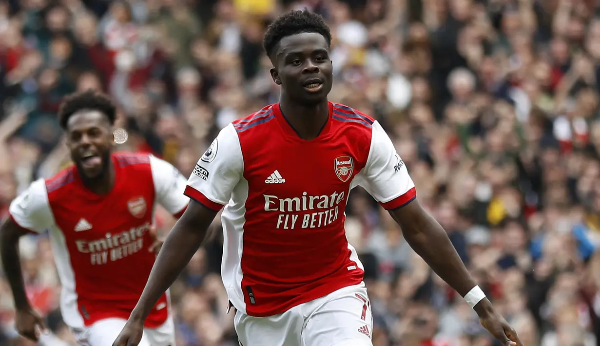 Bukayo Saka. Sayap kanan Inggris berusia 20 tahun yang memperkuat Arsenal sejak awal musim 2019/2020 usai dipromosikan dari tim U-23 ini mampu mencetak 11 gol dan 7 assist dari 38 laga di Liga Inggris selama musim 2021/2022. Dengan raihan tersebut, pemilik jersey bernomor punggung 7 ini sekaligus menjadi top skor klub mengalahkan Emile Smith Rowe dan Martin Odegaard yang masing-masing mencetak 10 dan 7 gol di Liga Inggris. (AFP/IKImages/Ian Kington)
