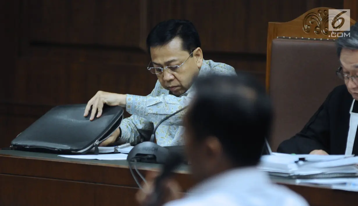 Terdakwa dugaan korupsi proyek e-KTP, Setya Novanto melihat berkas saat menyimak keterangan saksi pada sidang lanjutan di Pengadilan Tipikor, Jakarta, Senin (12/3). Sidang mendengar keterangan saksi dan saksi ahli. (Liputan6.com/Helmi Fithriansyah)