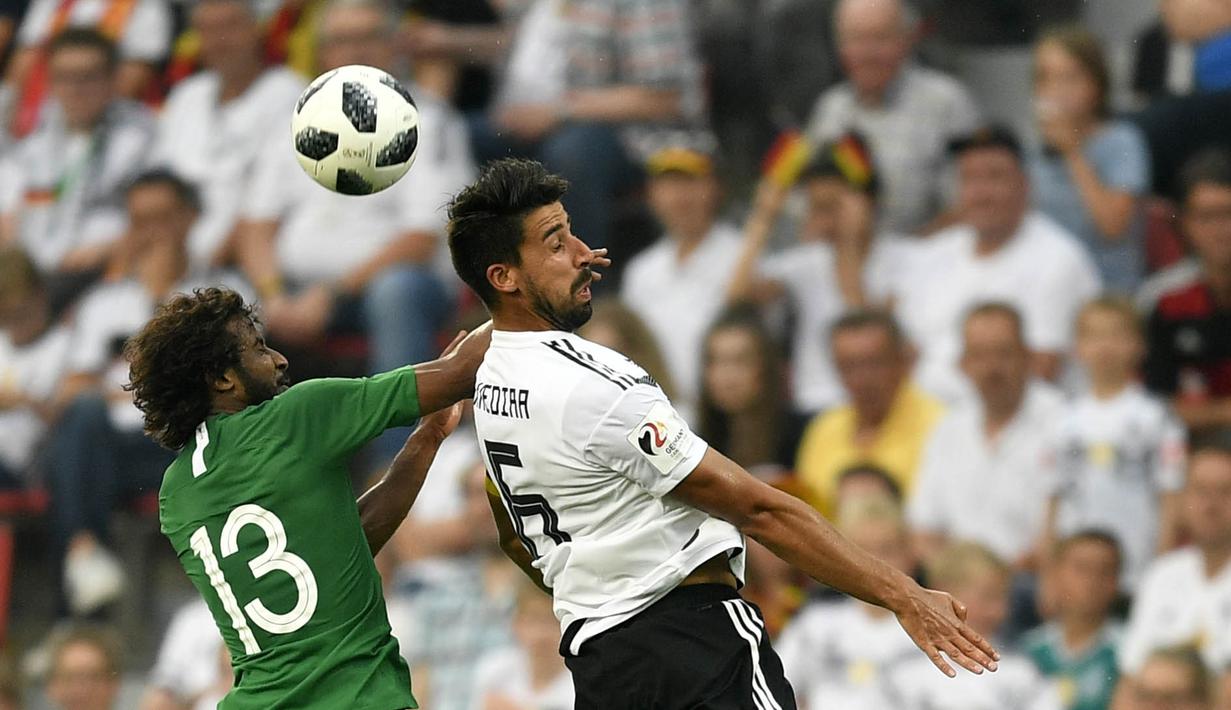 Gelandang Jerman, Samy Khedira, duel udara bek Arab Saudi, Yasser Al-Shahrani, pada laga uji coba di Stadion BayArena, Jumat (8/6/2018). Jerman menang 2-1 atas Arab Saudi. (AP/Martin Meissner)