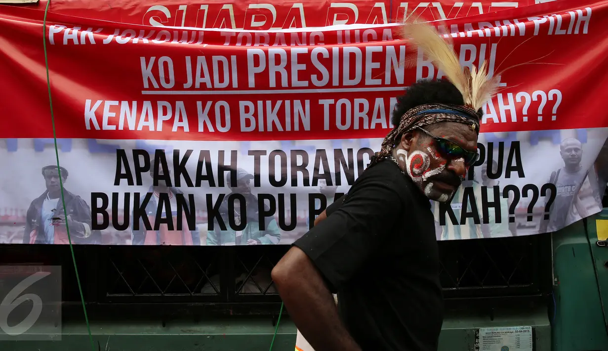 Seorang demonstran berdiri didekat spanduk besar saat berunjuk rasa di depan Kementerian Energi dan Sumber Daya Mineral (ESDM) Jakarta, Selasa (7/3). (Liputan6.com/Johan Tallo)