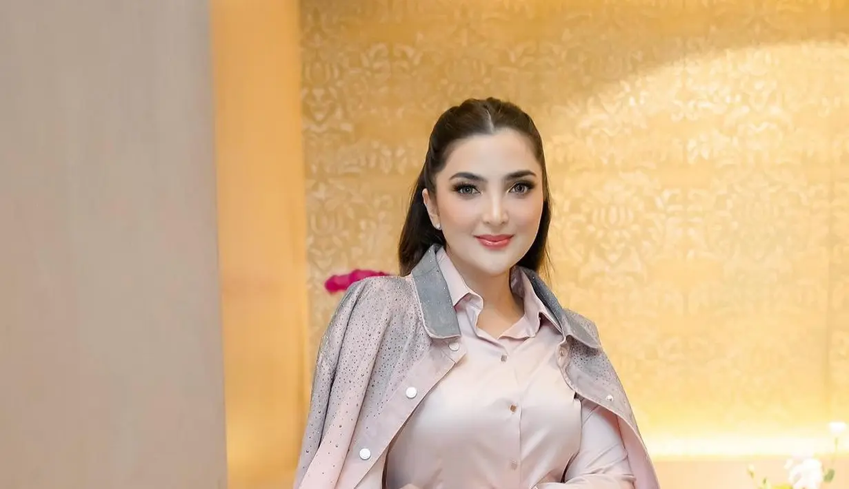 <p>Setelan jaket dan rok yang dikenakan memiliki warna gradasi pink abu-abu. Detail beads di pundak dan pinggang bikin tampilan simplenya terlihat elegan [@ashanty_ash]</p>