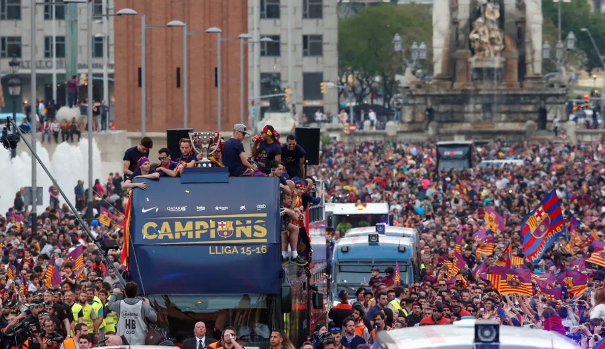 Ribuan orang berkumpul di jalanan kota Barcelona untuk menyambut tim Barcelona yang berpawai dengan menggunakan bus untuk merayakan gelar La Liga ke-24, Minggu (15/5/2016). (AFP/Pau Barrena)
