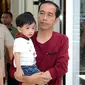 Presiden Jokowi sambil menggendong sang cucu, Jan Ethes menikmati libur akhir pekan di Mall Paragon, Solo, Jumat (30/3). Libur panjang akhir pekan ini dimanfaatkan Jokowi untuk berkumpul bersama keluarganya. (Liputan6.com/Pool/Kris-Biro Pers Setpres)