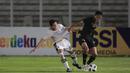 Bek Bali United, Ricky Fajrin, saat berebut bola dengan bek Timnas Indonesia pada laga uji coba di Stadion Madya, Minggu (7/3/2021). (Bola.com/ Ikhwan Yanuar Harun)