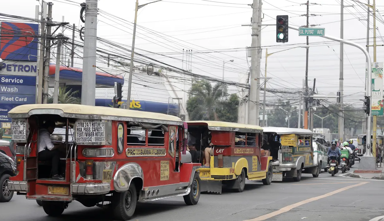 Deretan mobil Jeepney terjebak di antara kemacetan yang terjadi di Manila, Filipina, Jumat (22/11). Jeepney merupakan transportasi umum paling populer dan sudah menjadi ikon di Filipina. (Bola.com/M Iqbal Ichsan)