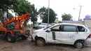 Petugas menderek mobil yang rusak akibat terjangan Tsunami Selat Sunda di Terminal Carita, Banten, Selasa (25/12). Terminal ini dijadikan tempat penampungan mobil yang hancur akibat tsunami. (Liputan6.com/Angga Yuniar)