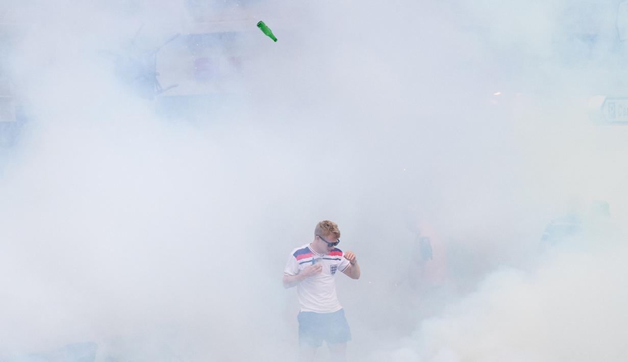 Seorang suporter Inggris terjebak dalam gas air mata yang dilepaskan polisi saat terjadi keributan antar suporter di Marseille, Prancis, (10/6/2016), jelang pertandingan melawan Rusia. (AFP/Leon Neal)