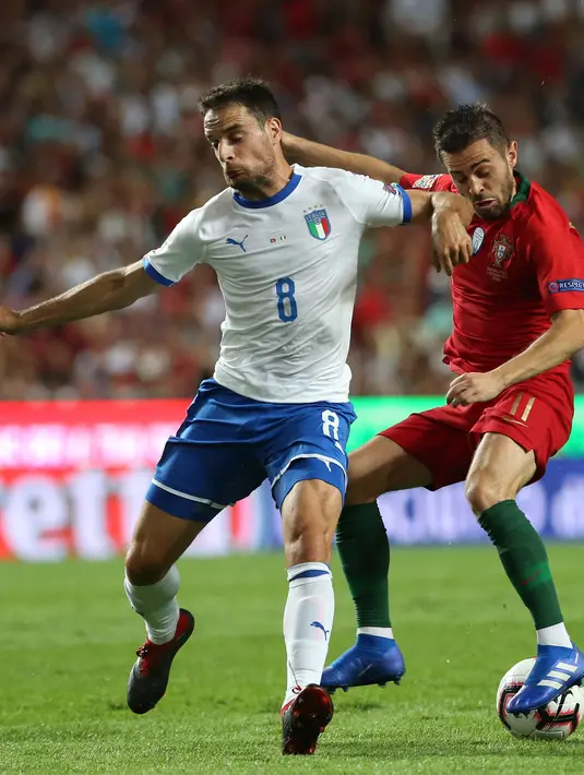 Gelandang Italia, Giacomo Bonaventura (kiri) berebut bola dengan gelandang Portugal Bernardo Silva saat bertanding dalam pertandingan UEFA Nations League di Stadion Luz, Lisbon, Portugal, (11/9). Portugal tipis 1-0 atas Italia. (AP Photo/Armando Franca)
