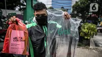 Driver Grab Bike menunjukkan Grab Protect pelindung yang membatasi antara pengemudi dan penumpang saat diluncurkan di Jakarta, Selasa (9/6/2020). Penumpang ojek online (ojol) kini tak perlu khawatir menggunakan transportasi ini di tengah pandemi Corona. (Liputan6.com/Faizal Fanani)