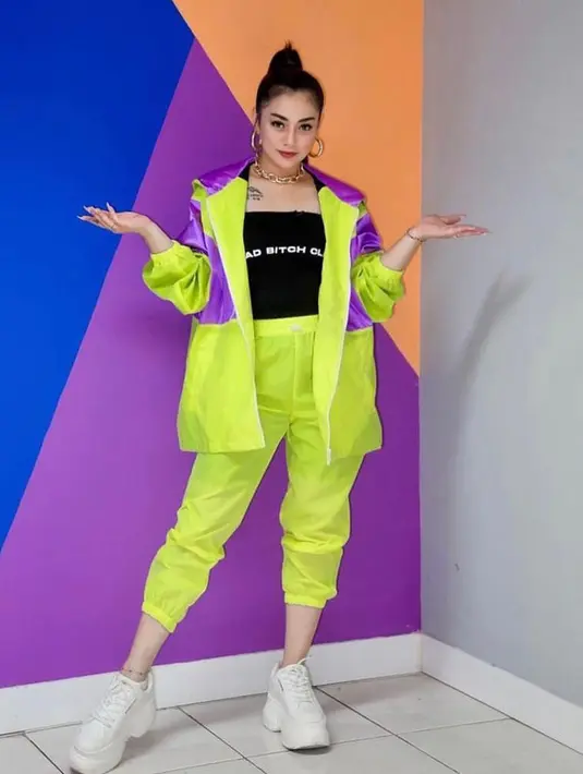 Gaya edgy Celine dengan jaket dan celana jogger warna neon. @celine_evangelista.
