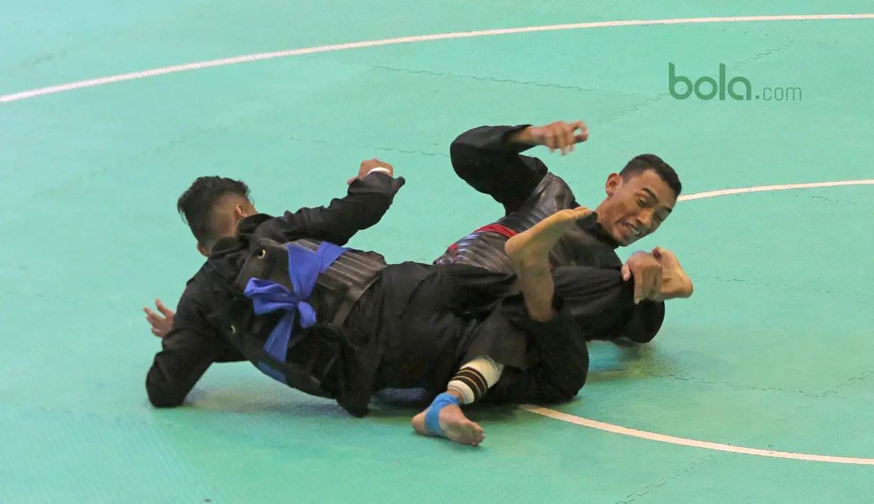 Aksi Arafa M. Yachser (kanan) mengunci pesilat Malaysia, Shukor M. Z. Hakim pada semifinal putra kelas 55 kg - 60 kg Test Event Asian Games  2018 di Padepokan Silat TMII, Jakarta, (12/2/2018). Arafa menang 5-0. (Bola.com/Nick Hanoatubun)