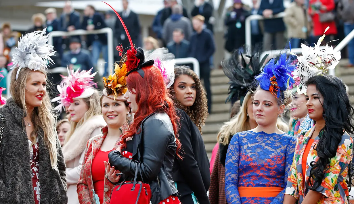Gaya sejumlah wanita cantik jelang pembukaan ajang Pacuan Kuda dalam Festival Cheltenham di Inggris (16/3). Ladies Day merupakan berkumpulnya wanita-wanita cantik berpakaian seperti bangsawan. (REUTERS/Paul Childs)