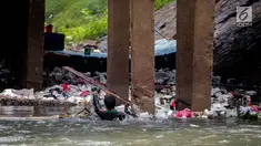 Aksi petugas PPSU bersihkan sampah yang tersangkut ditengah deras arus aliran anak kali Ciliwung, Jakarta, Senin (22/7/2019). Pembersihan sungai dari berbagai sampah tersebut dimaksudkan agar tidak ada penumpukan sampah dan sedimentasi saluran di sepanjang sungai. (Liputan6.com/Faizal Fanani)