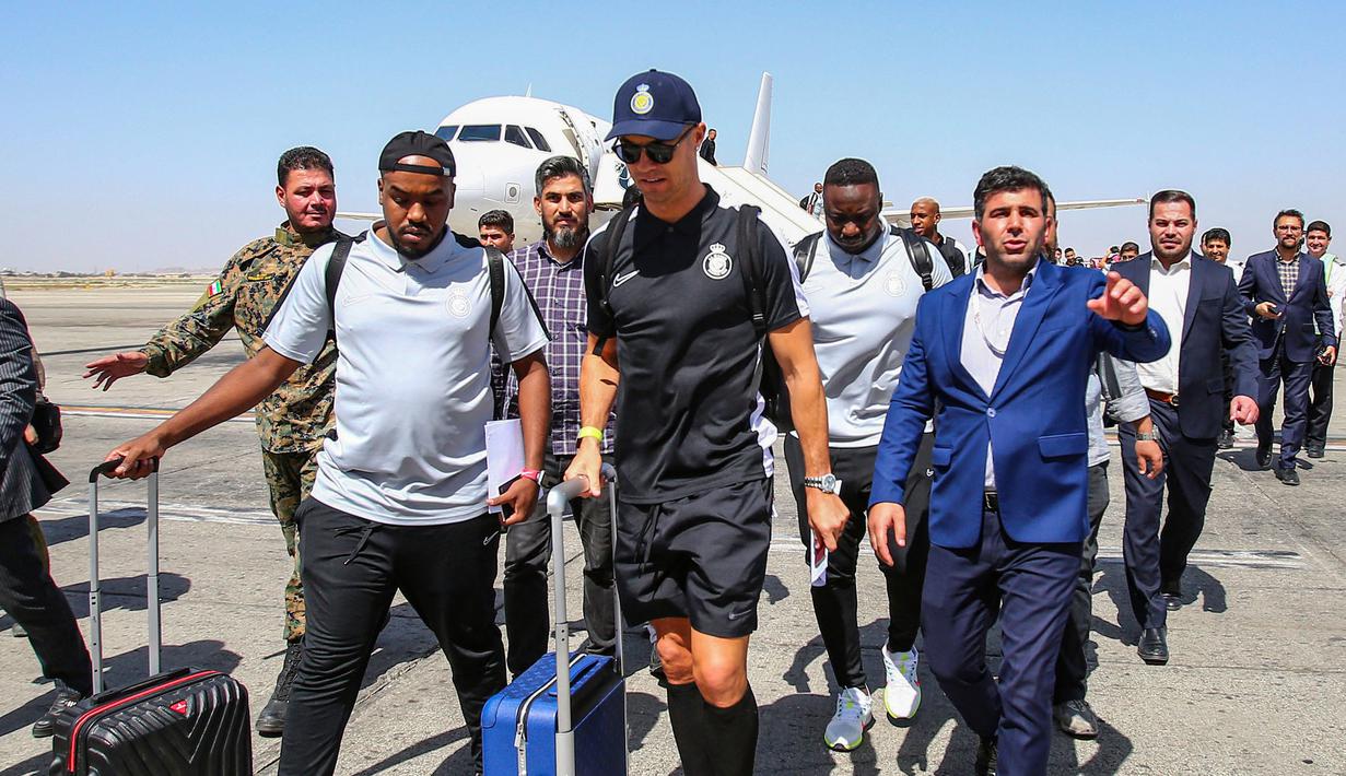 Pemain Al-Nassr, Cristiano Ronaldo berjalan ke luar dari Imam Khomeini International Airport, Tehran pada Selasa (19/09/2023). Al-Nassr akan melakoni laga grup G Liga Champions Asia 2023 melawan Persepolis FC pada Rabu (20/09/2023). (AFP/Payam Parsae)