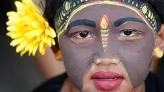 Seorang pemuda berpartisipasi dalam ritual Hindu "Grebeg" di Desa Tegallalang, Bali, Rabu (30/1). Dalam ritual dua tahunan ini, para pemuda berkeliling kampung dengan riasan tubuh warna-warni untuk menangkal Roh jahat. (AP/Firdia Lisnawati)