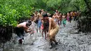 Sejumlah warga terlihat bersemangat saat mengikuti tradisi Mebuug-buugan atau mandi lumpur di desa Kedonganan, Denpasar, Bali (10/3). Mebuug-buugan diadakan sehari usai hari raya Nyepi. (AFP/Sonny Tumbelaka)