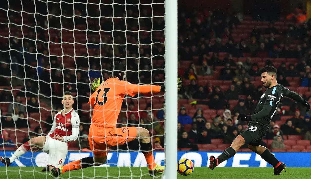 Striker Manchester City, Sergio Aguero, berusaha membobol gawang Arsenal yang dijaga Petr Cech pada laga Premier League di Stadion Emirates, London, Kamis (1/3/2018). Arsenal kalah 0-3 dari City. (AFP/Glyn Kirk)